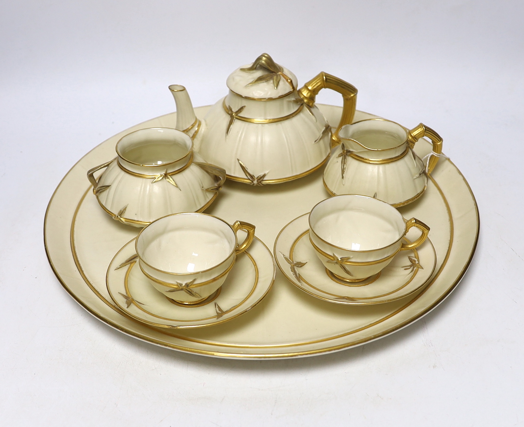 A late 19th century Royal Worcester ivory ground and gilt decorated cabaret set, tray 37cm diameter